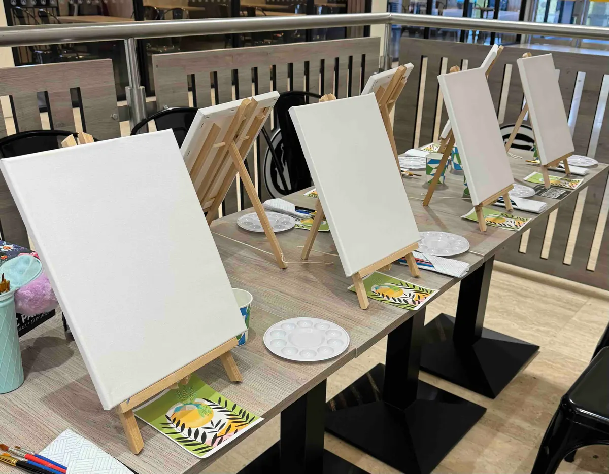 Blank canvases set up on easels for a canvas painting workshop.
